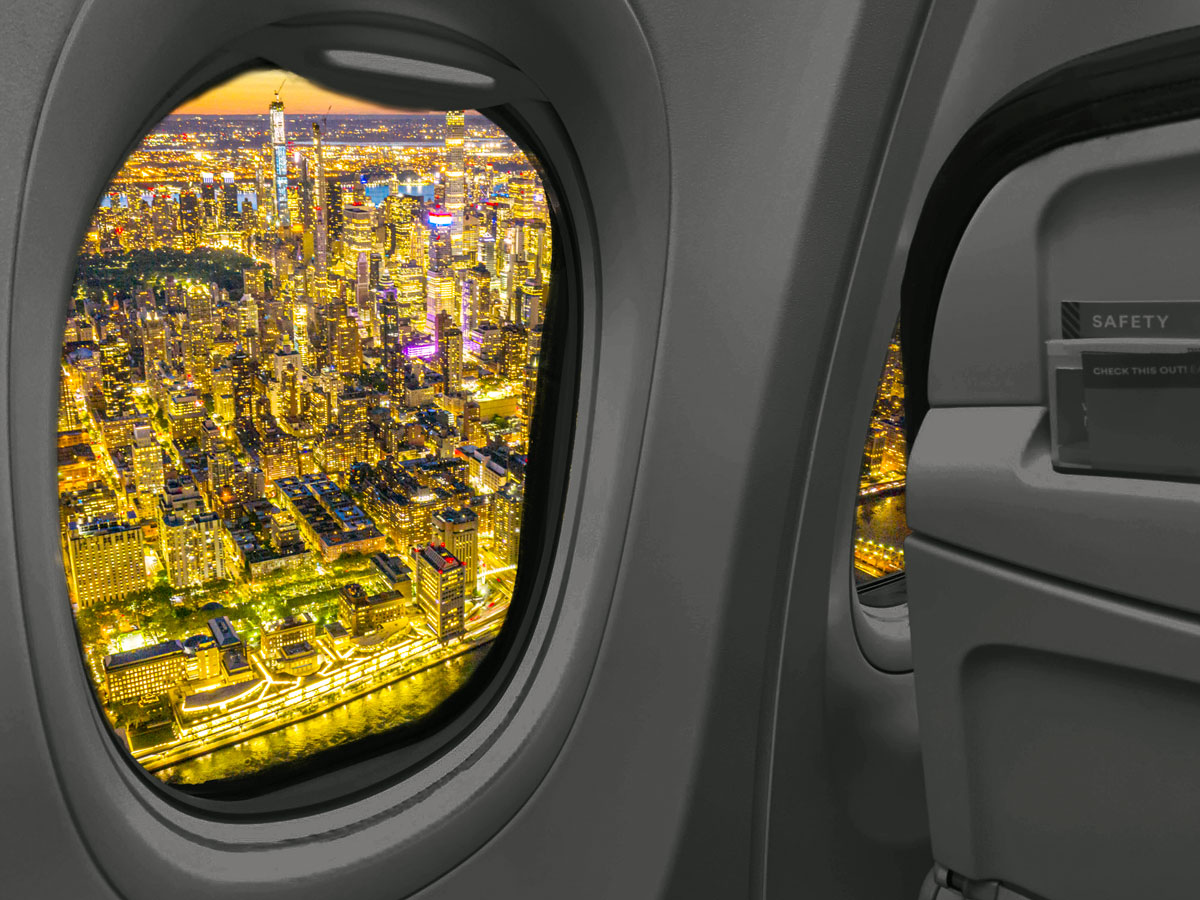 View of bright city lights at night from airplane window