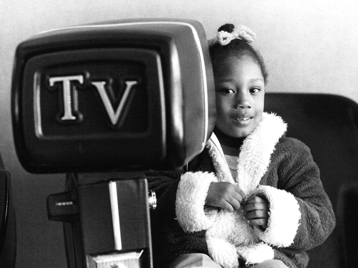 Child enjoying TV chair in vintage photo