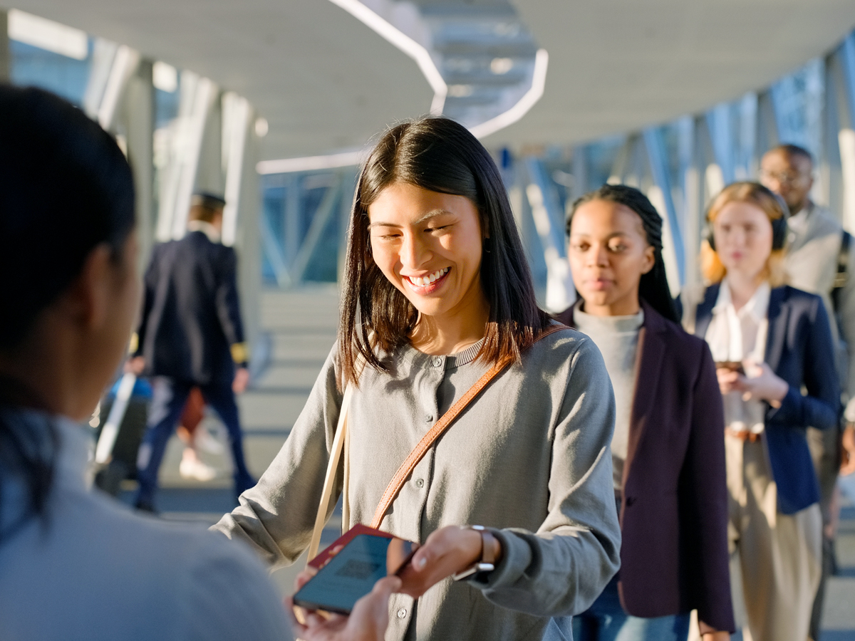 Passenger showing mobile boarding pass to gate agent