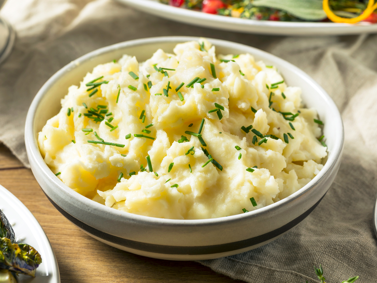 Bowl of mashed potatoes garnished with chives