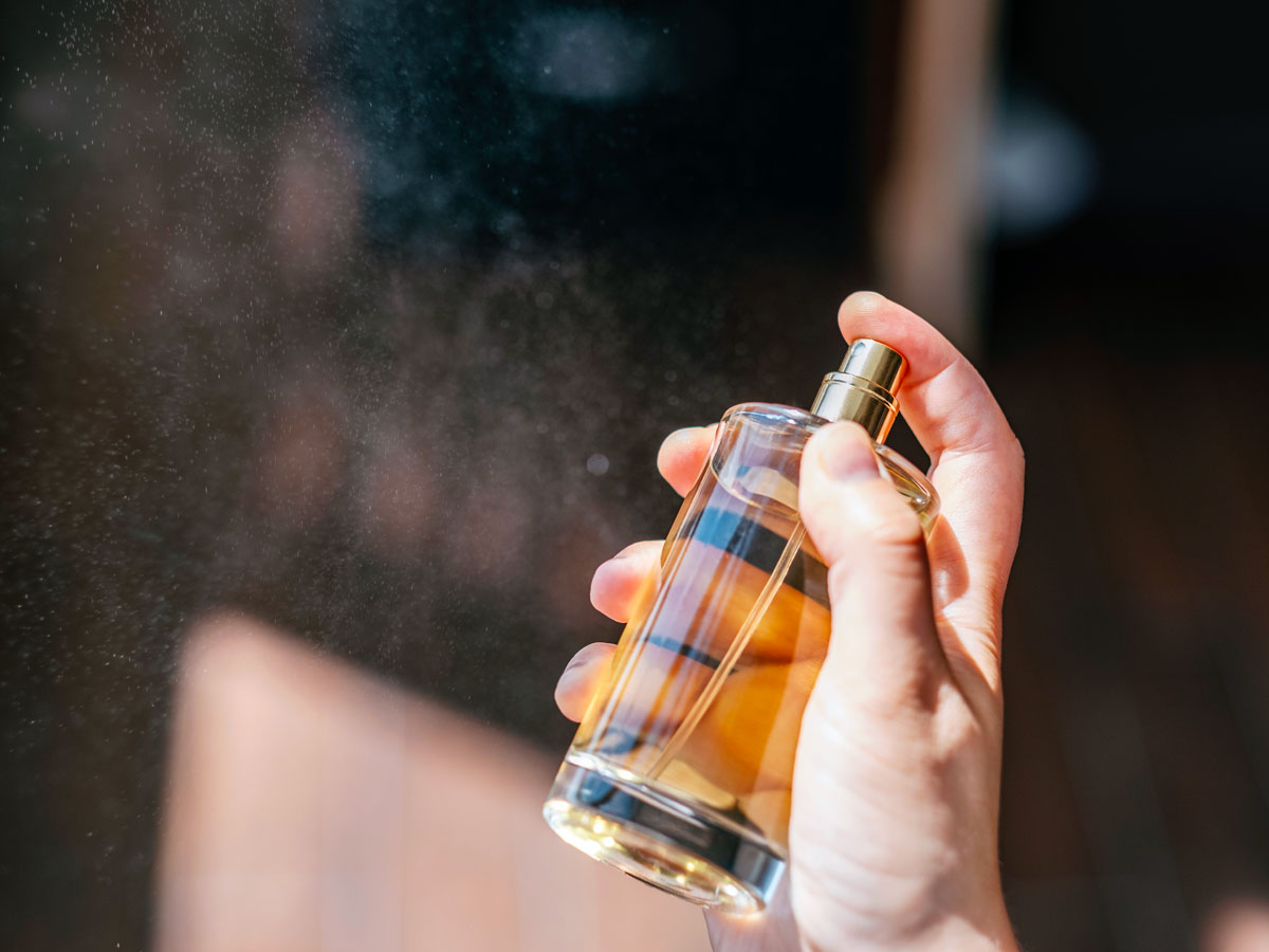 Person spraying perfume bottle
