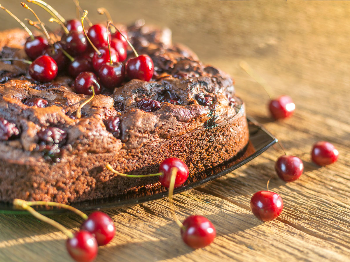 Caribbean black cake with cherries on counter