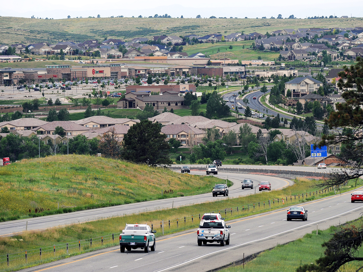 Cars driving by suburban community on E-470 in Colorado