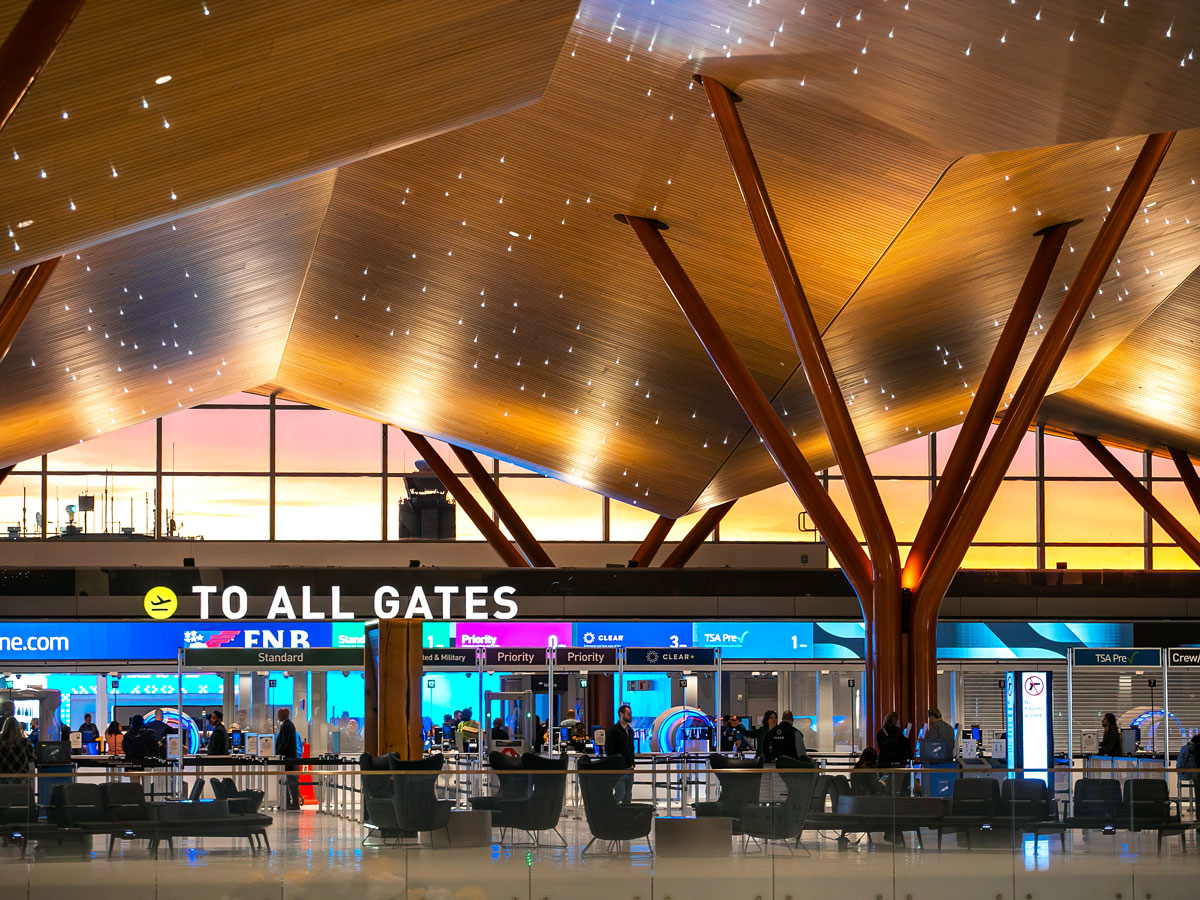 Sign toward all gates under undulating wood ceilings at the new Pittsburgh International Airport