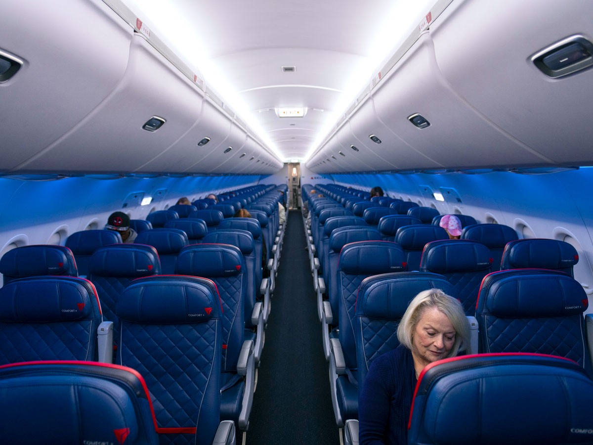Economy-class cabin on Delta Air Lines aircraft looking from front to back
