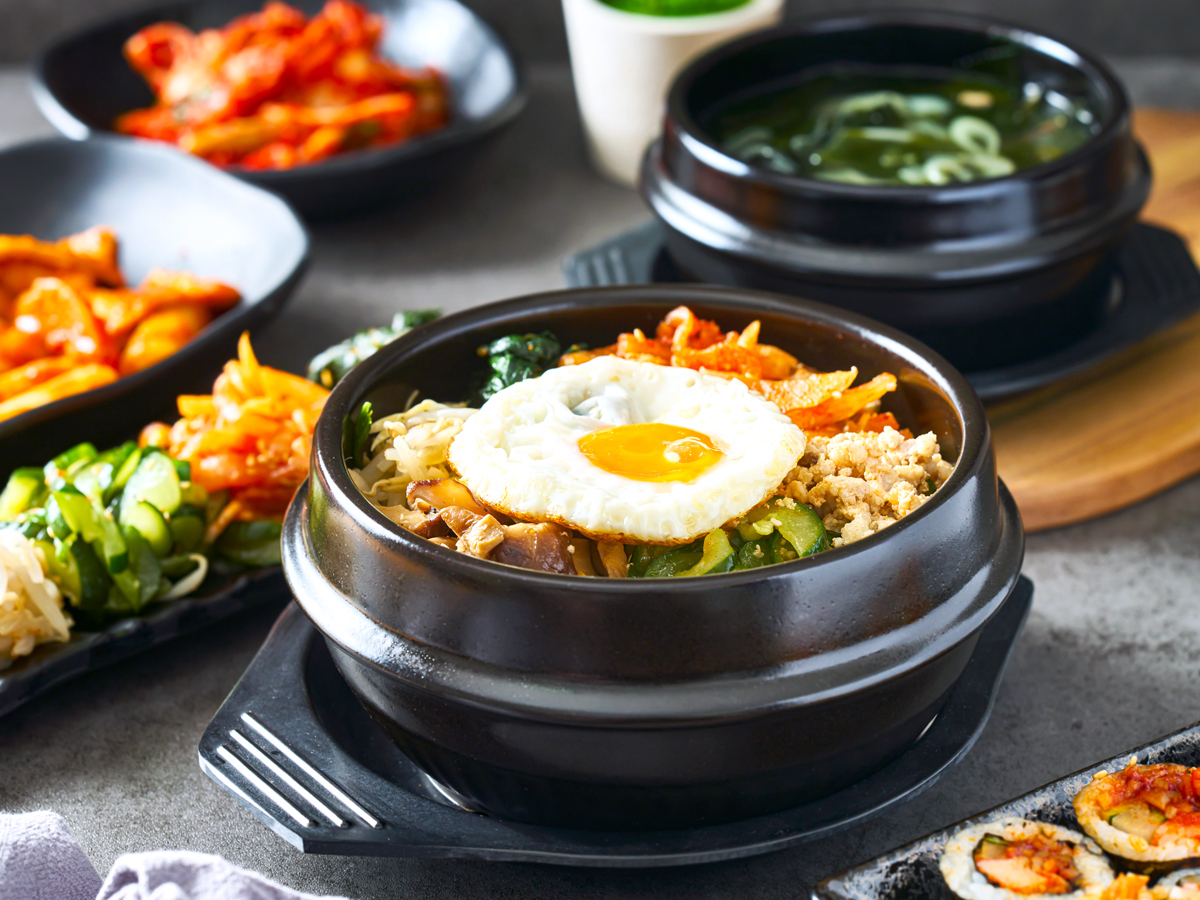 Bowl of bibimbap alongside other traditional Korean dishes