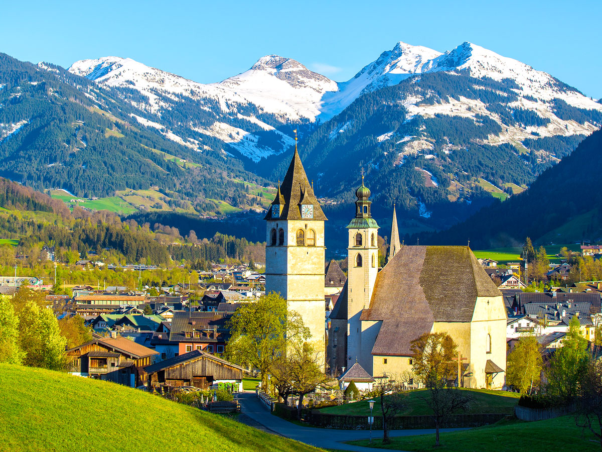 Church surrounded by mountains in town of Kitzbühel, Austria
