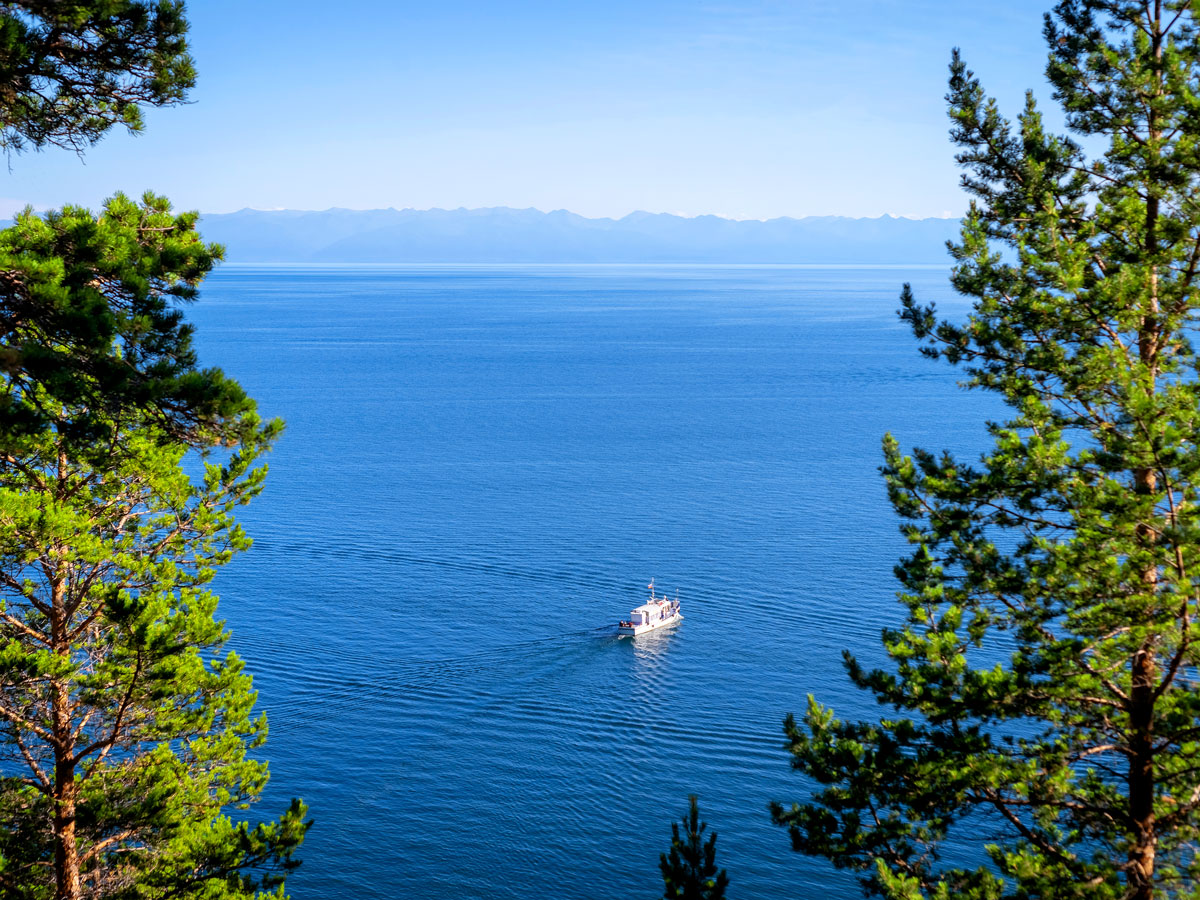 Tourist boat on Lake Baikal framed by trees