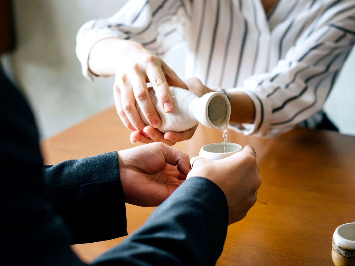 One person pouring another a drink