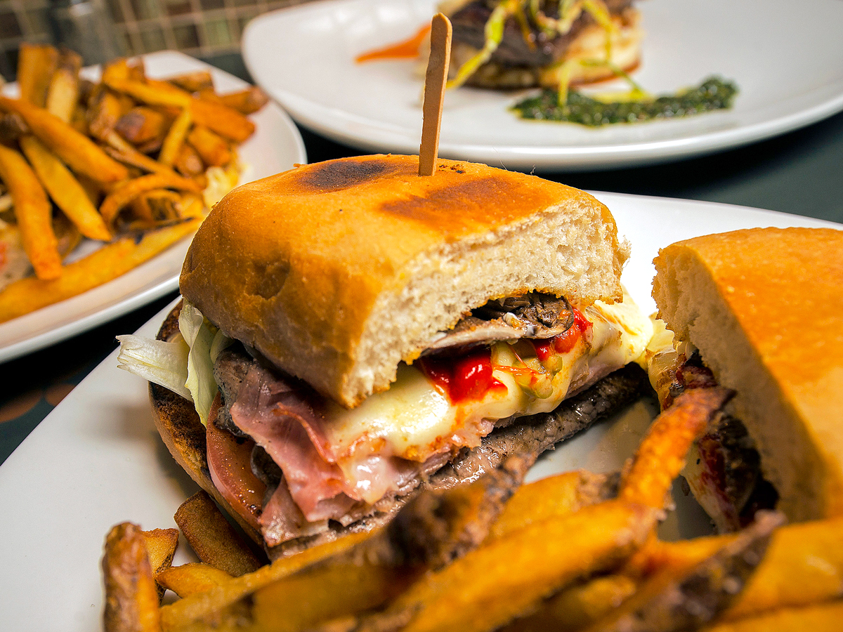 Chivito sandwich on plate with French fries
