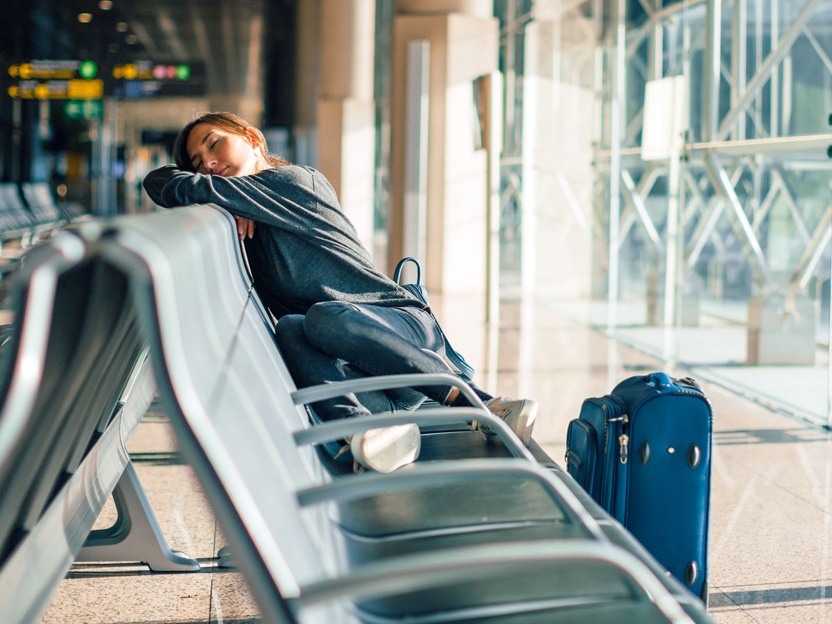 Traveler resting at airport gate seating