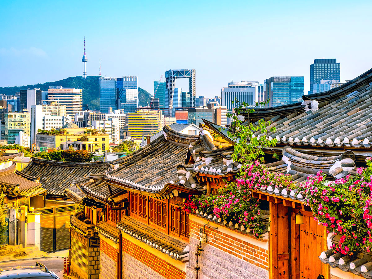 Traditional houses with modern skyscrapers of Seoul in distance
