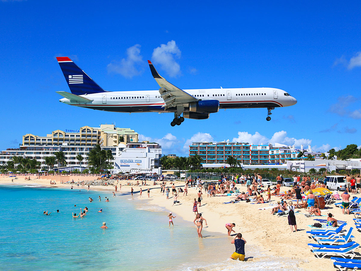 Aircraft landing over beachgoers at Princess Juliana International Airport in St. Maarten