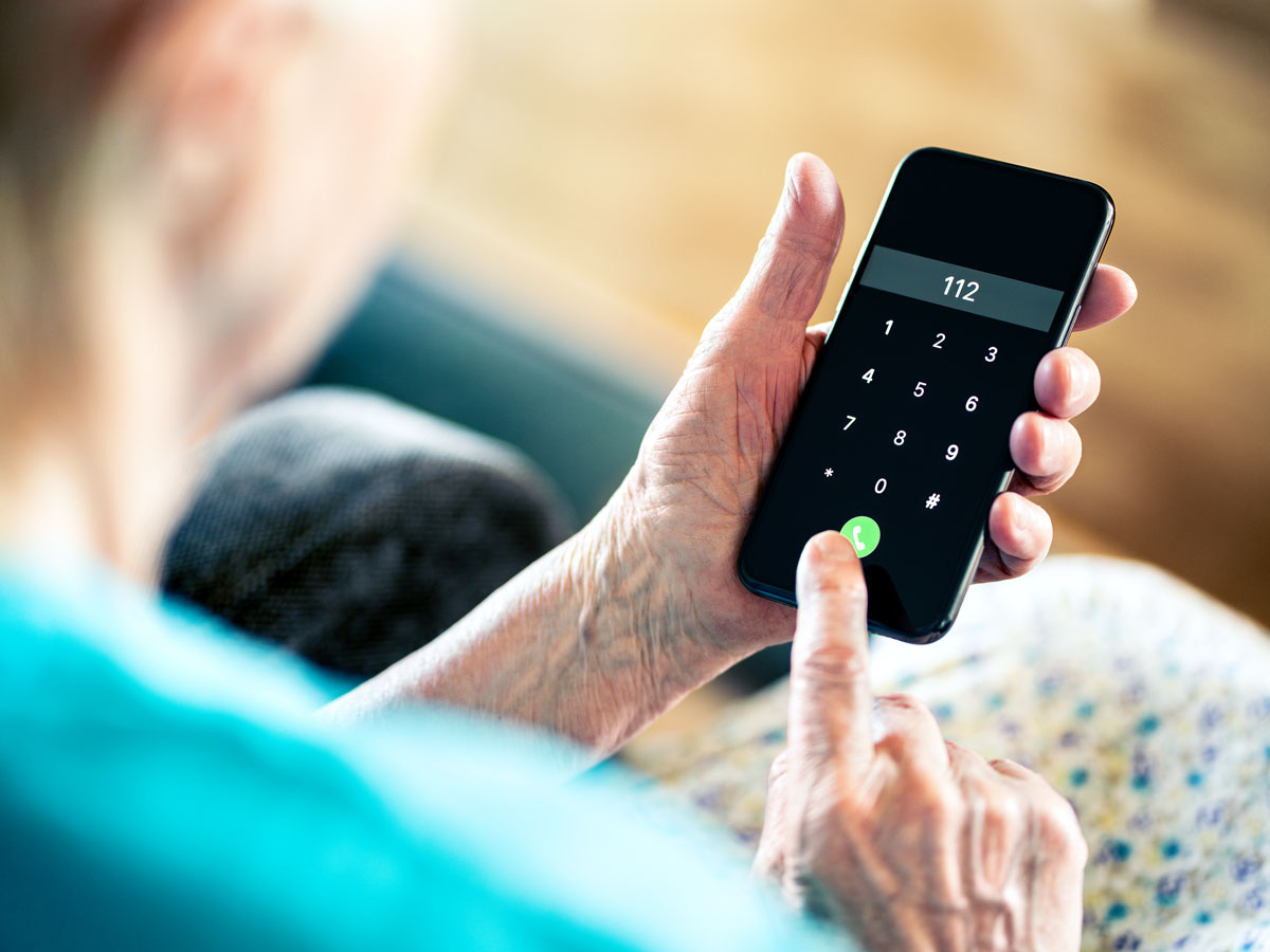 Person dialing 112 emergency number on cellphone