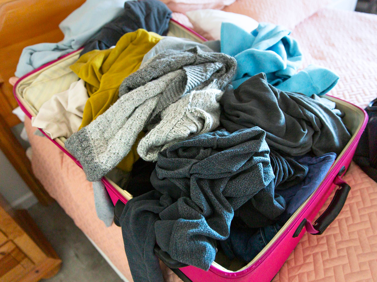 Clothes in suitcase on bed