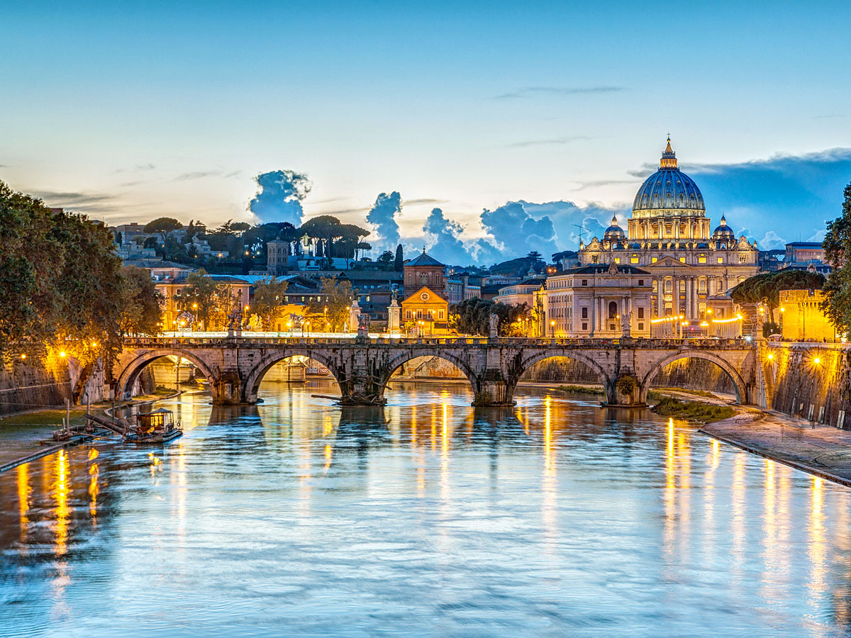 Bridge over the Tiber River with view of St. Peter's Basilica at dusk