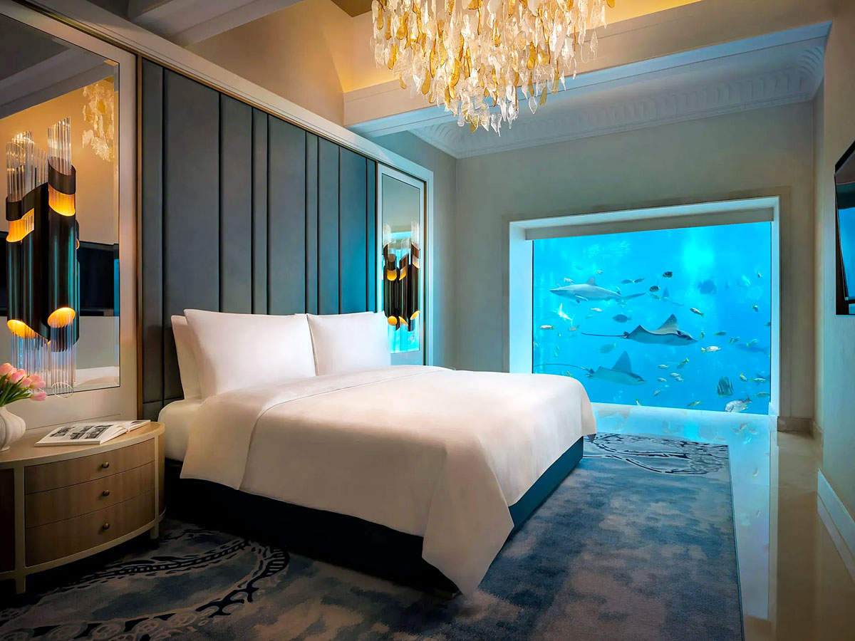 Underwater suite at Atlantis Dubai with bed overlooking marine life
