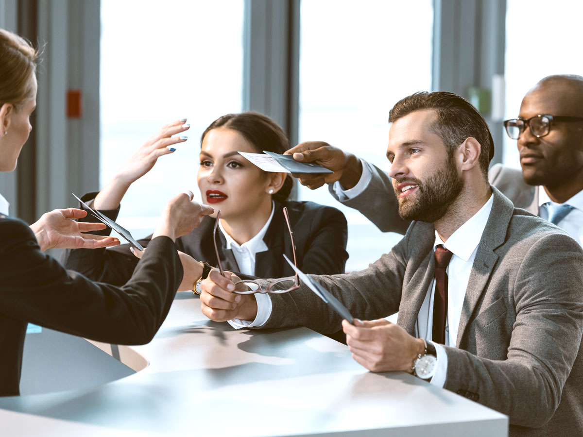 Travelers speaking with airport gate agent