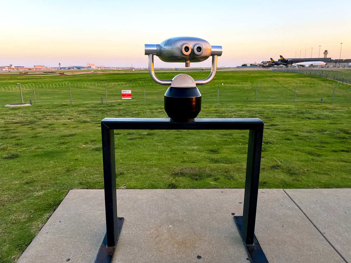 Binoculars overlooking runway at Dallas Fort Worth International Airport in Texas