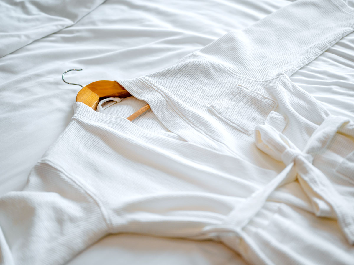 Bathrobe laying on hotel bedspread