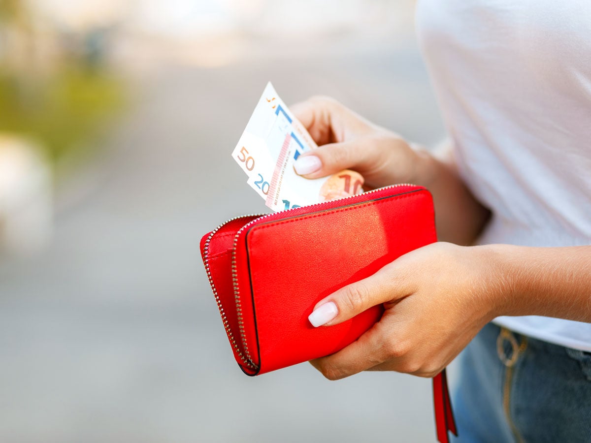 Person taking euros out of red wallet