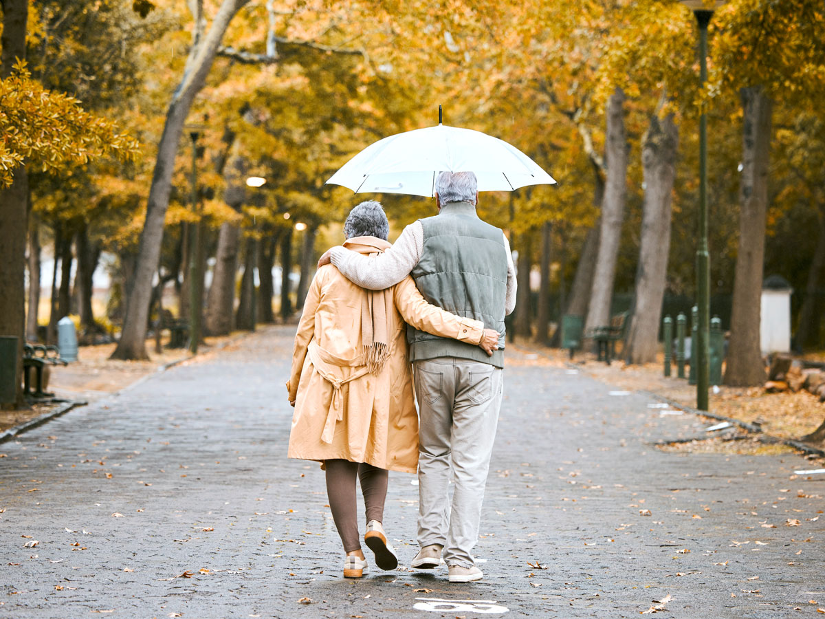 Senior couple walking in the rain through Central Park in New York City