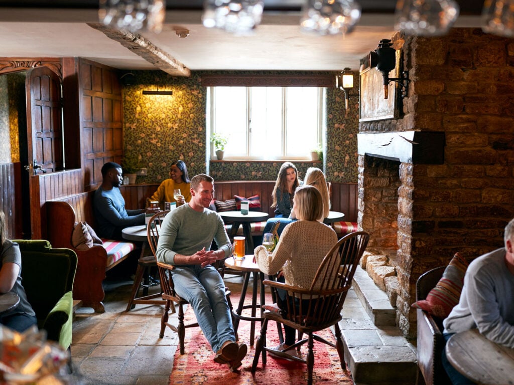 Hotel guests having drinks by fireplace in lobby