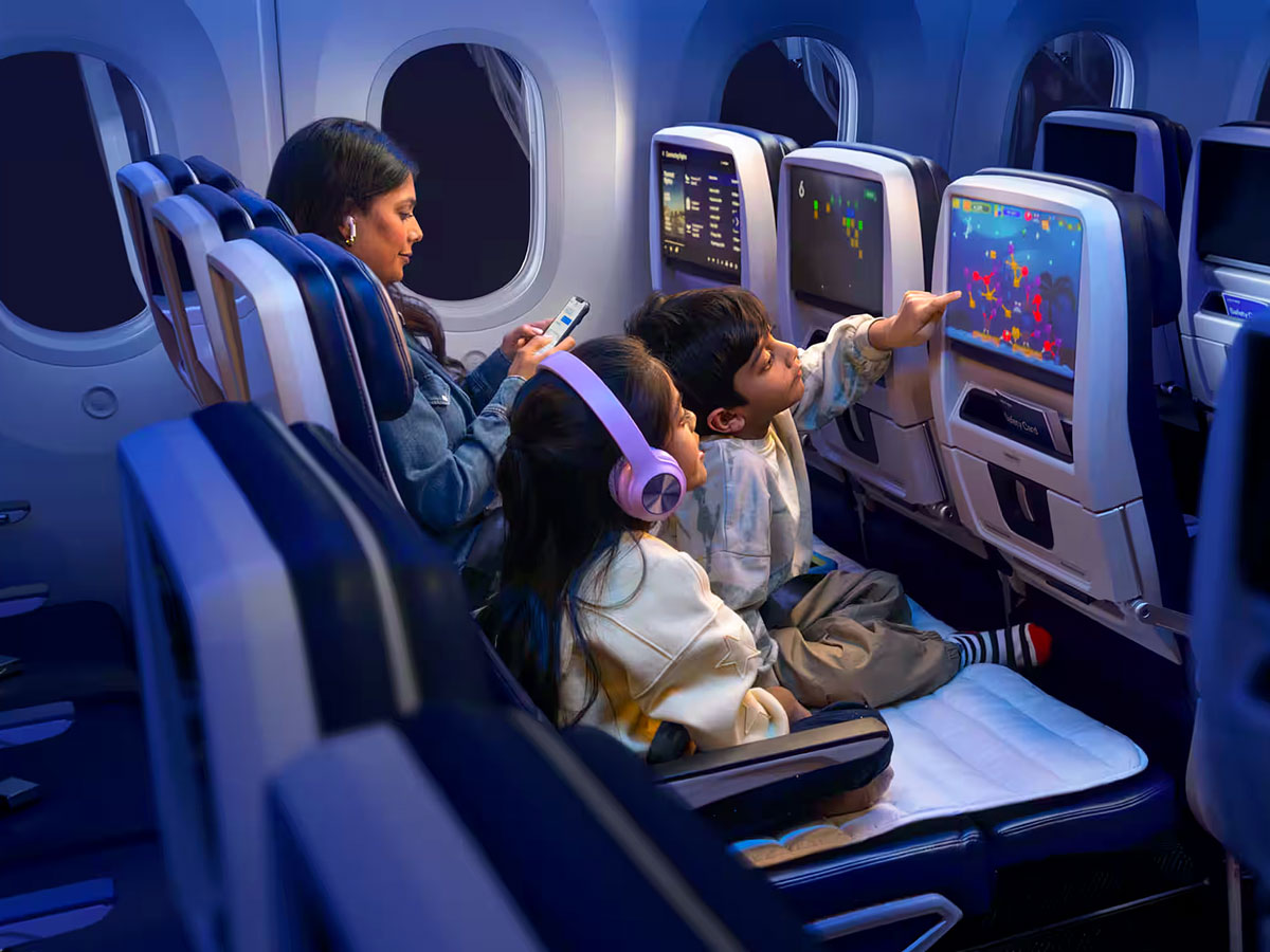 Family seated in row of economy-class seats on airplane