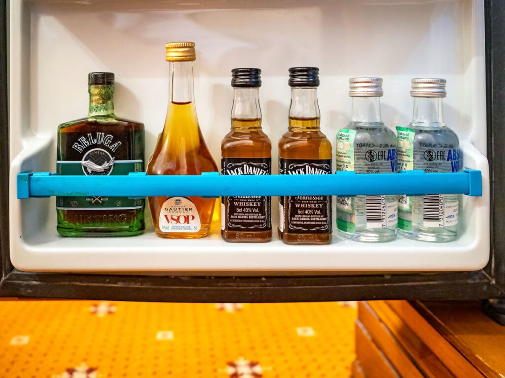 Door of hotel minibar stocked with mini liquor bottles