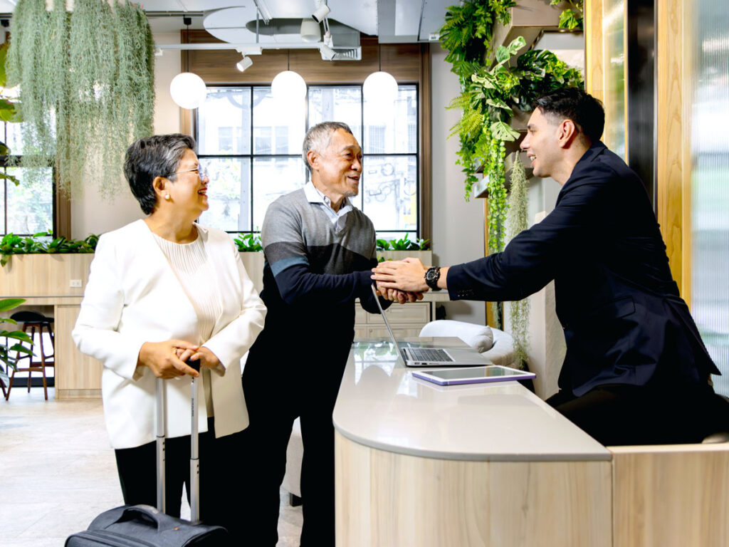 Couple interacting with hotel front desk employee
