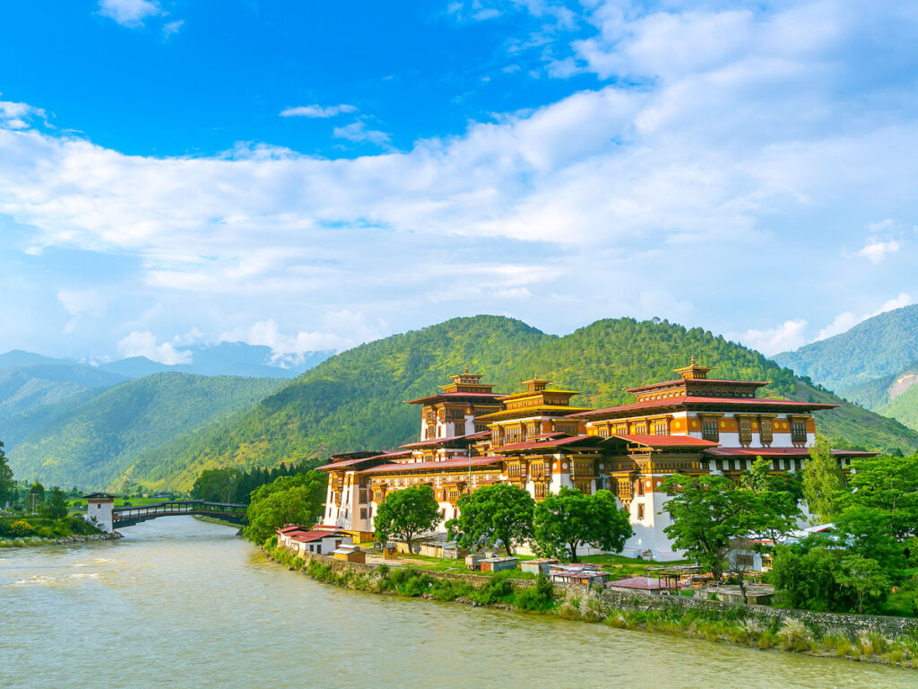 Buddhist temple beside river and mountains in Bhutan