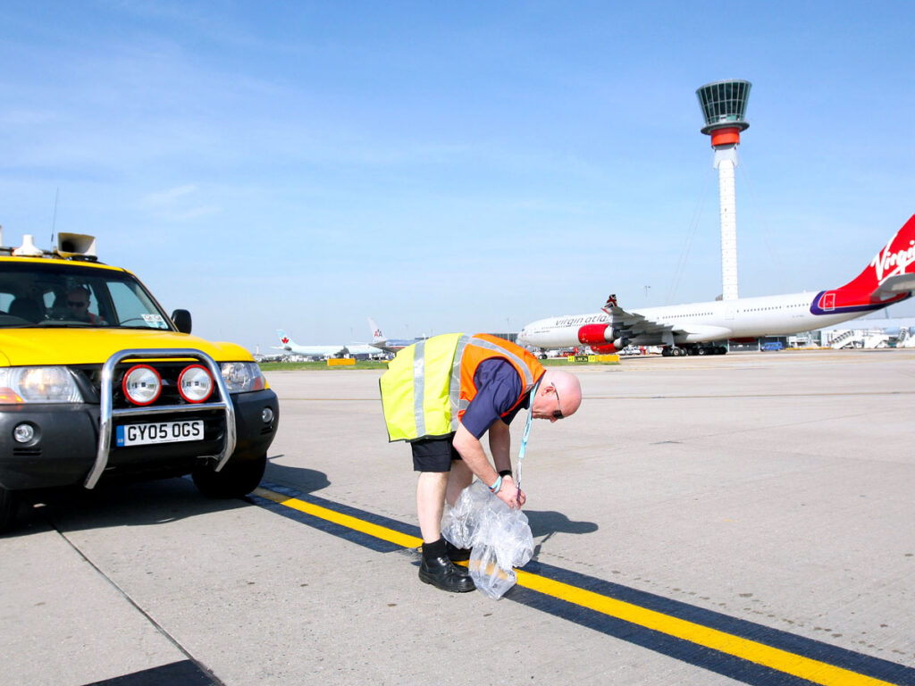 Inspector removing object on runway at airport